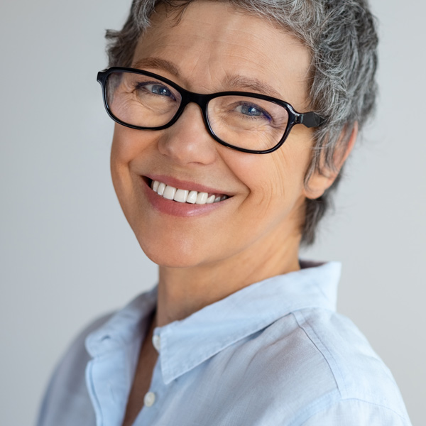older woman with glasses smiling